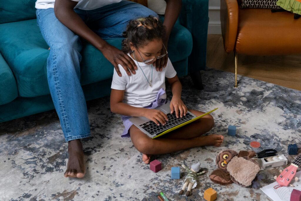 How Beginners Can Start a Profitable Tech Career A child and father engaging in educational play with a laptop indoors.