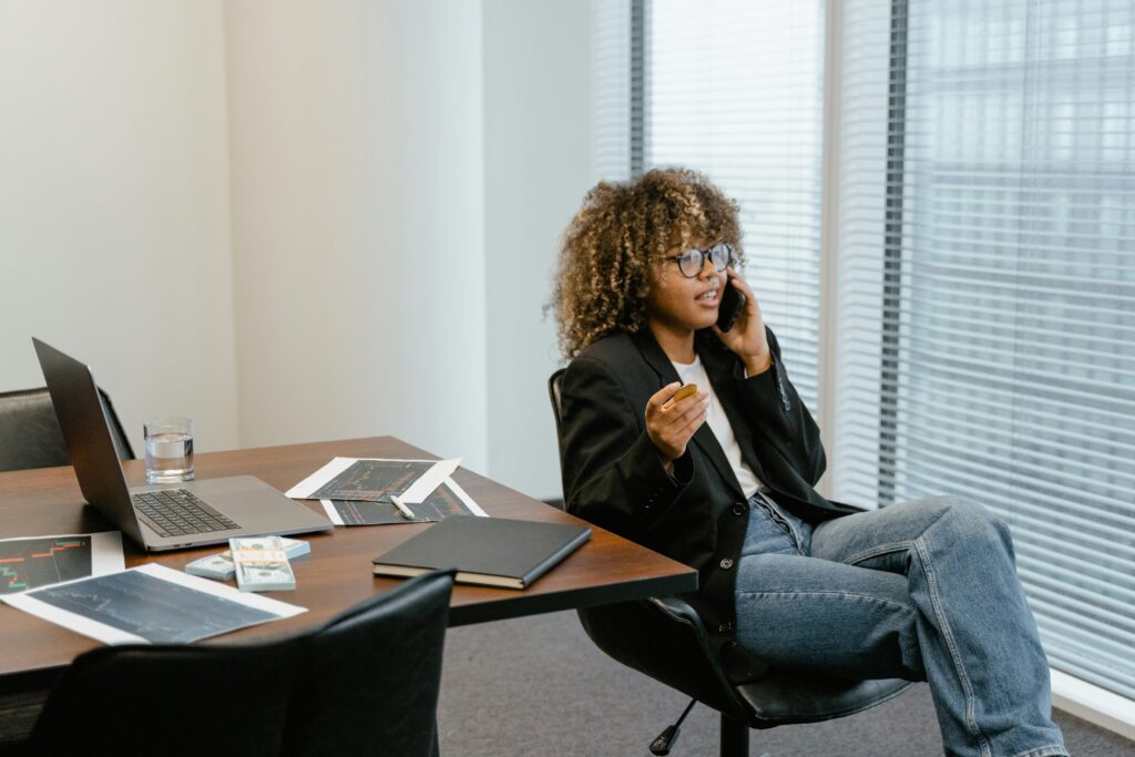 A business analyst engaged in work, sitting at a desk with a laptop and graphs.